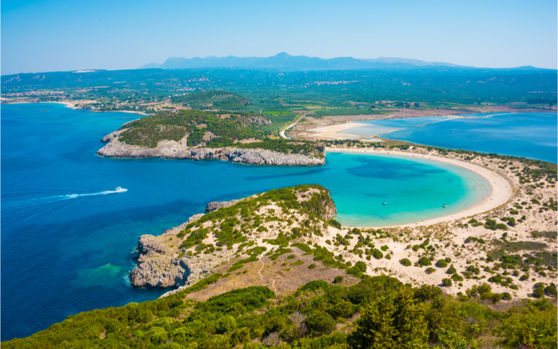 Bucht mit einem Strand der einen fast perfekten Halbkreis formt und türkises Meer