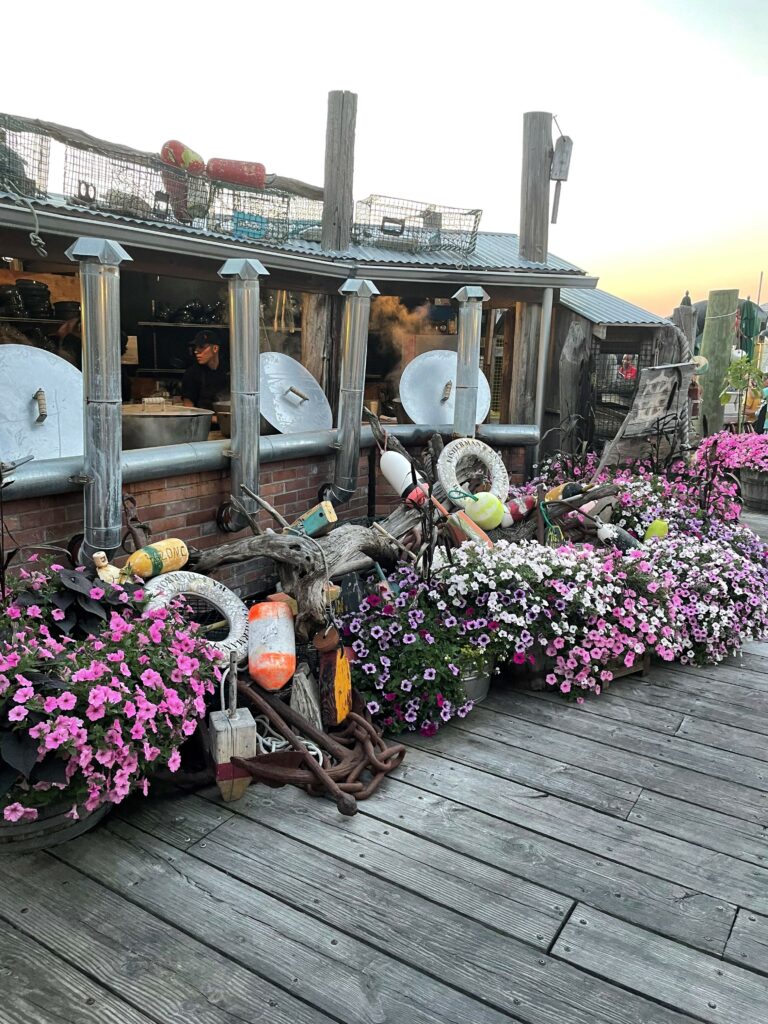 Küche vom Lokal mit Front-Cooking und schönen Blumen davor